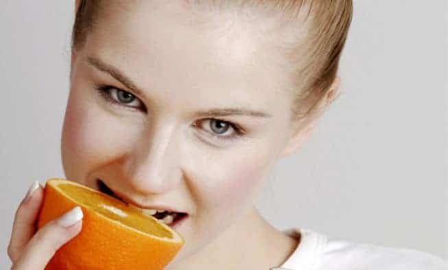 une femme mange des oranges