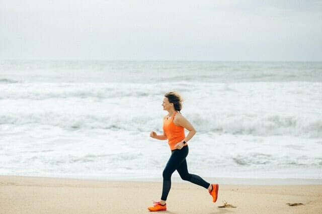  une femme court sur la plage