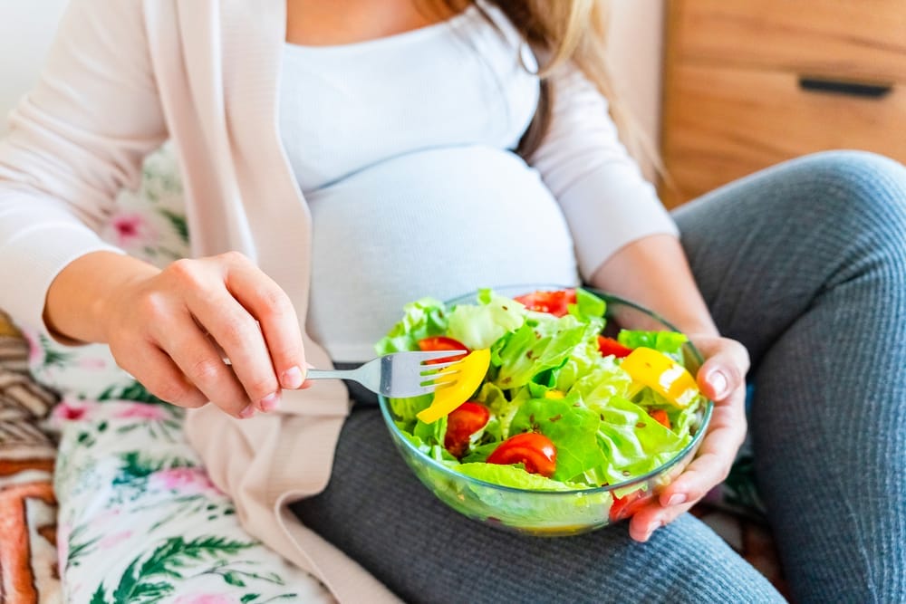 Une femme enceinte mange une salade